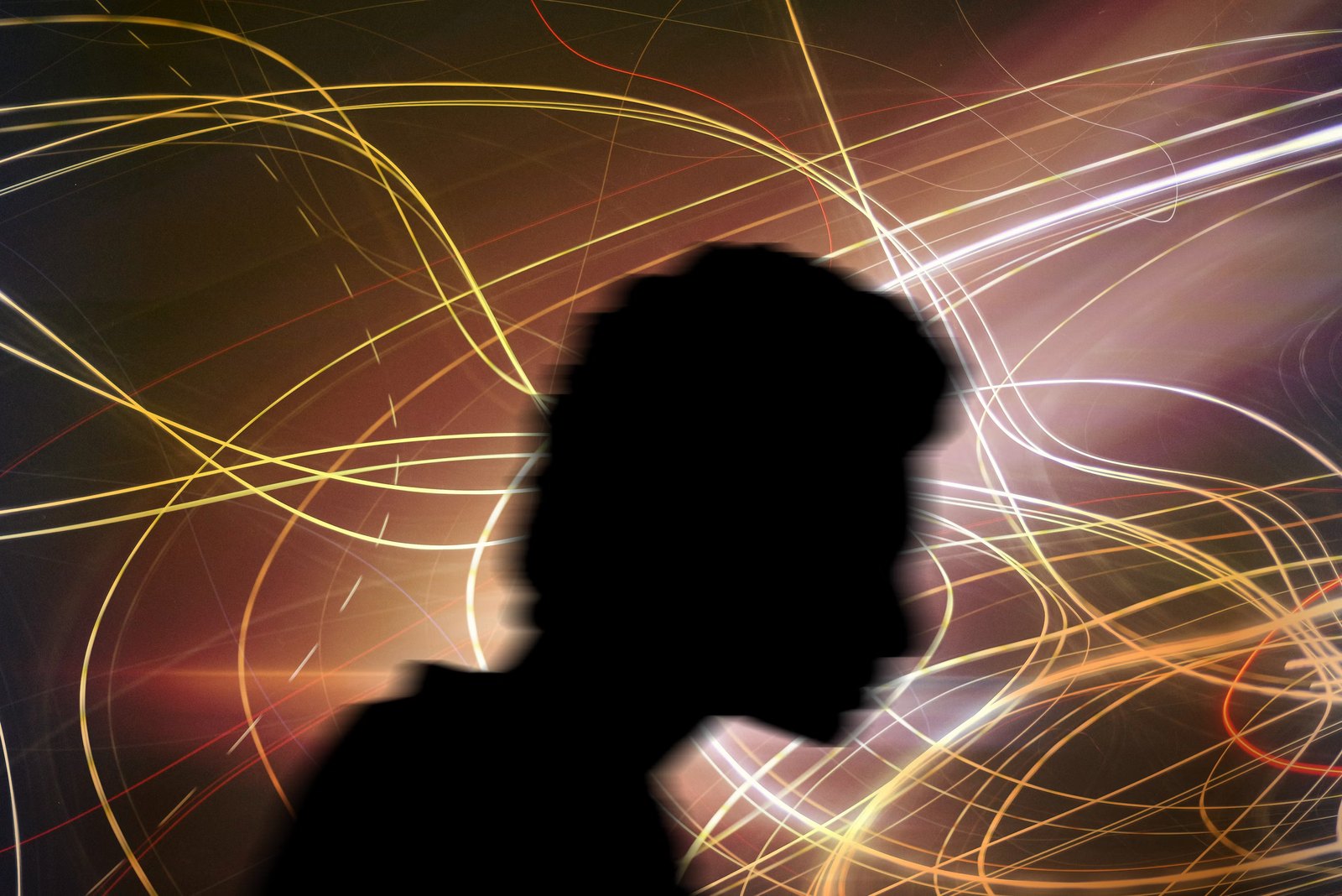 A silhouette with streaks of light spinning around the head