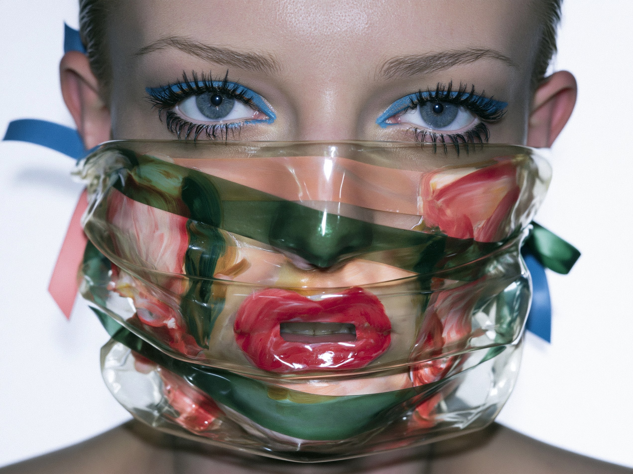 A close-up portrait, the lower face softened and obscured behind a translucent, distorting layer